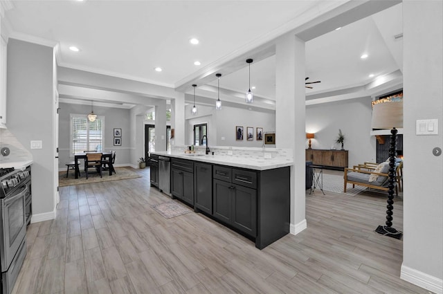 kitchen featuring light stone counters, hanging light fixtures, light hardwood / wood-style flooring, and appliances with stainless steel finishes