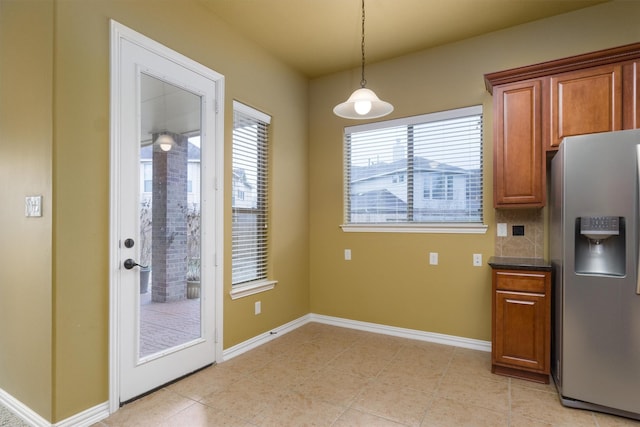 kitchen featuring light tile patterned flooring, stainless steel fridge, and decorative light fixtures