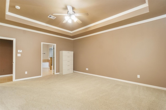 unfurnished bedroom featuring crown molding, light carpet, and a tray ceiling