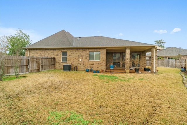 back of property with a yard and central air condition unit