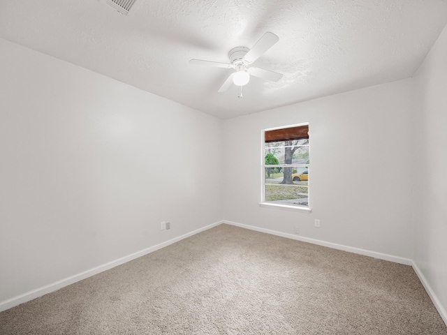 carpeted spare room with a textured ceiling and ceiling fan