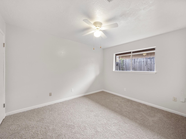 empty room featuring ceiling fan, carpet floors, and a textured ceiling