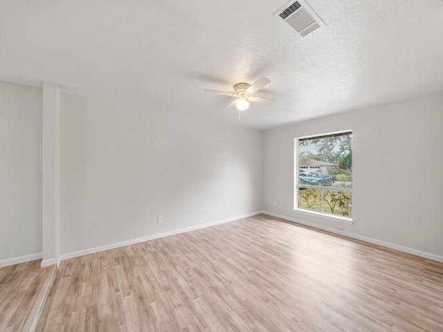 unfurnished room with ceiling fan, a textured ceiling, and light wood-type flooring