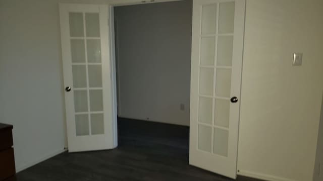 unfurnished room with dark hardwood / wood-style flooring