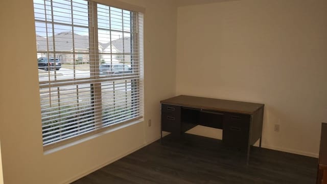 unfurnished room featuring dark hardwood / wood-style flooring and a wealth of natural light