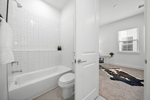 bathroom featuring tile patterned floors, toilet, and tiled shower / bath combo