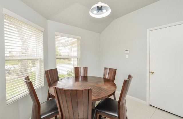 tiled dining area featuring vaulted ceiling