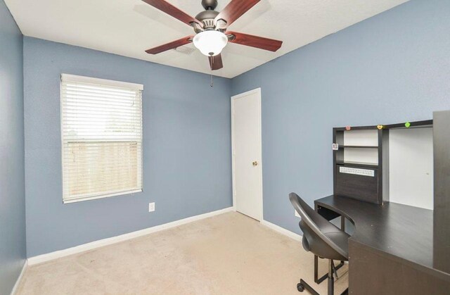 unfurnished office featuring ceiling fan and light carpet