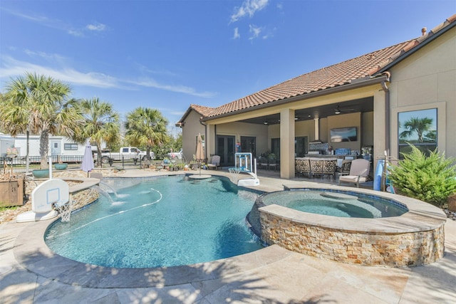 view of pool with a patio area, a pool with connected hot tub, fence, and a ceiling fan