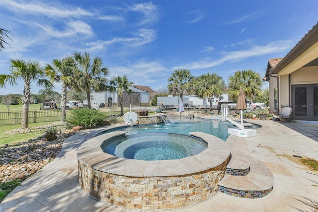 view of pool with a fenced in pool, fence, a patio, and an in ground hot tub