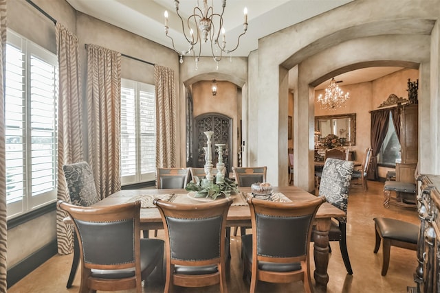 dining space featuring arched walkways and a notable chandelier