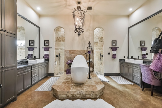 bathroom featuring a walk in shower, a freestanding tub, visible vents, vanity, and tile walls