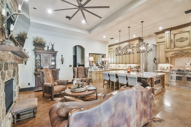 living area featuring visible vents, arched walkways, finished concrete floors, a fireplace, and recessed lighting