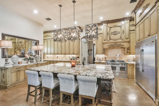 kitchen featuring premium appliances, a kitchen island with sink, concrete floors, visible vents, and a kitchen breakfast bar