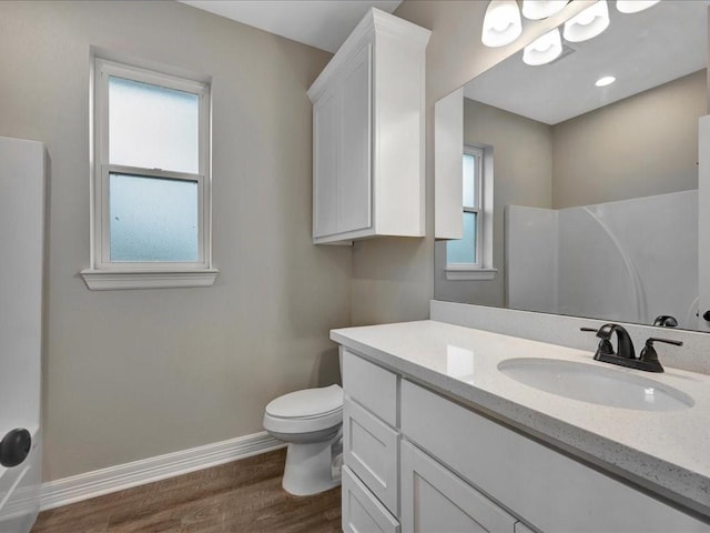 bathroom with vanity, a shower, hardwood / wood-style floors, and toilet