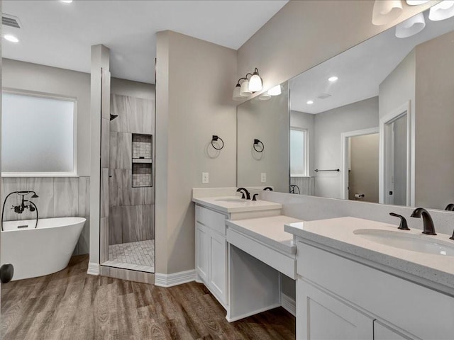 bathroom featuring independent shower and bath, wood-type flooring, and vanity