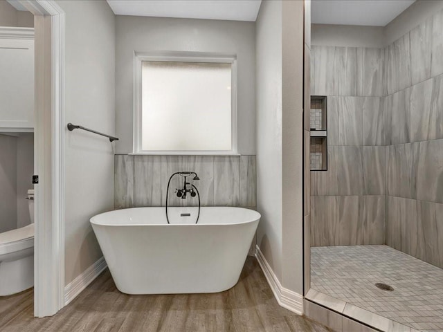 bathroom with toilet, separate shower and tub, and hardwood / wood-style floors