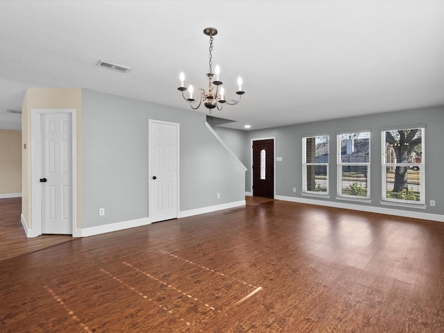 unfurnished living room featuring dark hardwood / wood-style floors and a notable chandelier