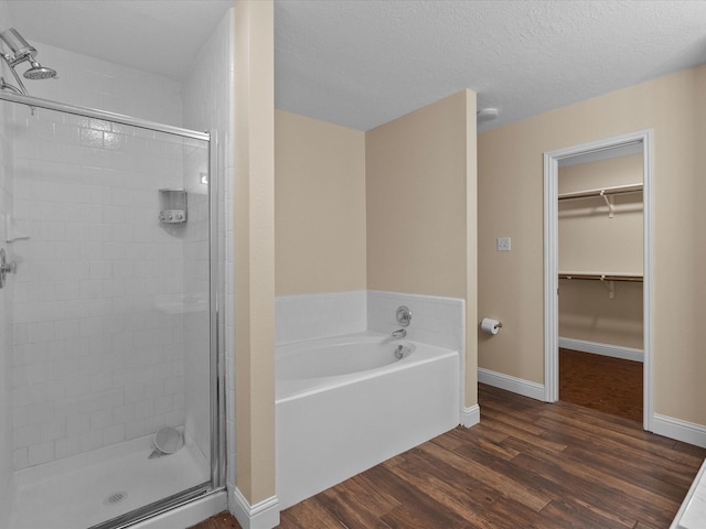 bathroom featuring hardwood / wood-style flooring, independent shower and bath, and a textured ceiling