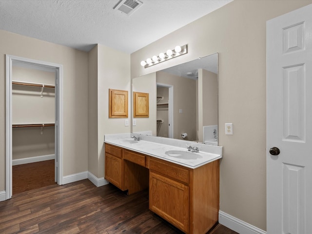 bathroom featuring hardwood / wood-style flooring, vanity, and a textured ceiling