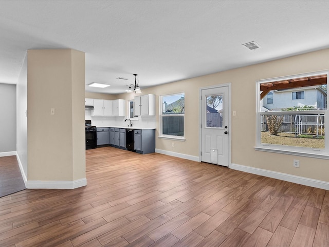 unfurnished living room with sink and light wood-type flooring