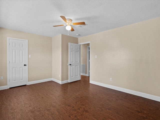 empty room with a textured ceiling, dark hardwood / wood-style floors, and ceiling fan