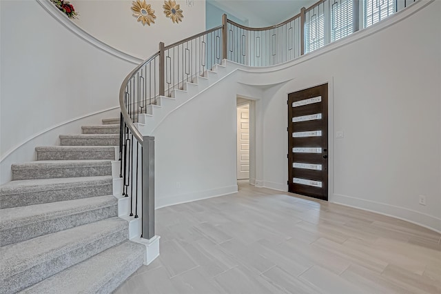 foyer featuring hardwood / wood-style flooring and a towering ceiling