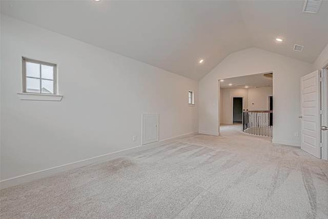 empty room with lofted ceiling and light colored carpet