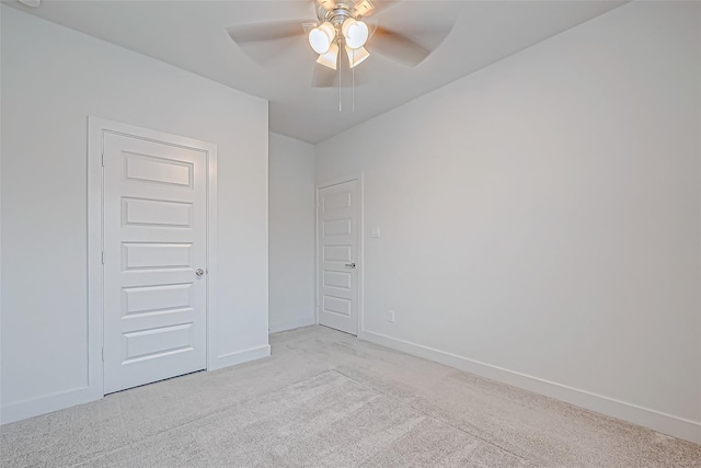 empty room with ceiling fan and light carpet