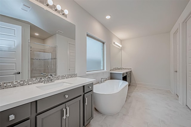 bathroom with vanity, independent shower and bath, and decorative backsplash