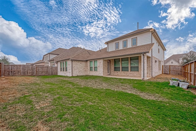 back of property with a yard and a patio area