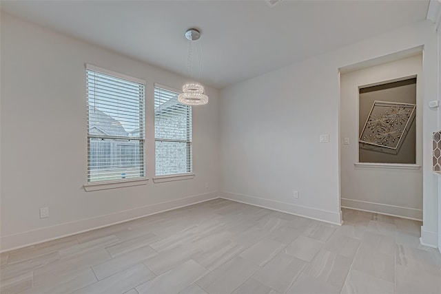 unfurnished room featuring a notable chandelier