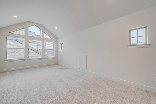 unfurnished room featuring light colored carpet and vaulted ceiling