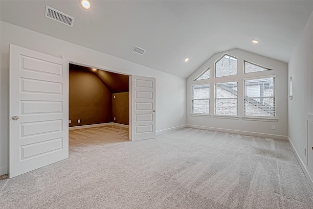 additional living space with lofted ceiling and light carpet