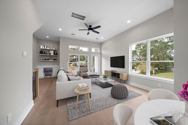 living room featuring wine cooler, ceiling fan, and light hardwood / wood-style flooring