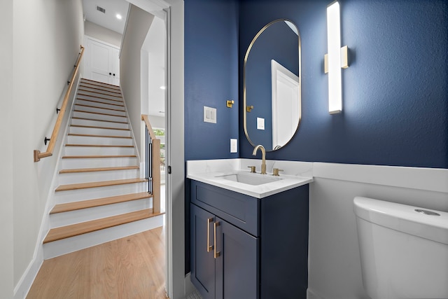 bathroom with vanity, toilet, and hardwood / wood-style floors