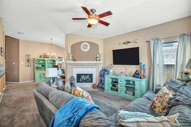 living room with ceiling fan with notable chandelier, lofted ceiling, carpet floors, and a tile fireplace