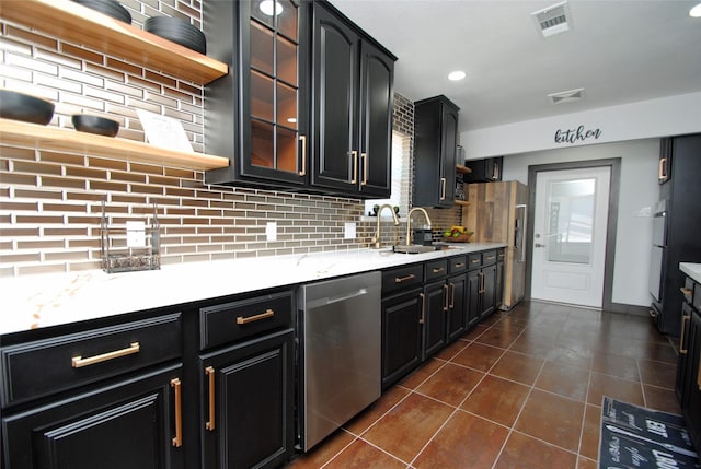 kitchen featuring appliances with stainless steel finishes, sink, backsplash, and dark tile patterned flooring