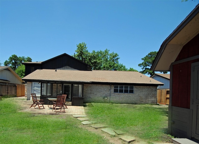 back of property with a patio area and a lawn