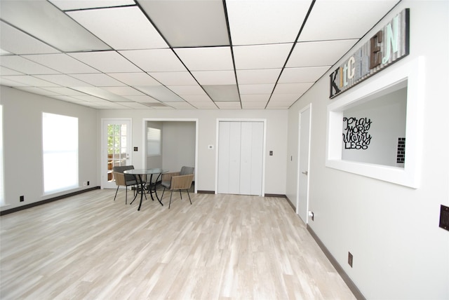 dining room featuring a drop ceiling and light hardwood / wood-style floors