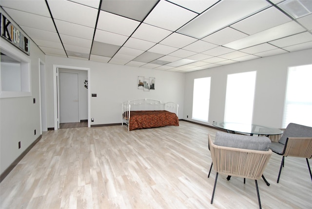 bedroom featuring a drop ceiling and light hardwood / wood-style floors