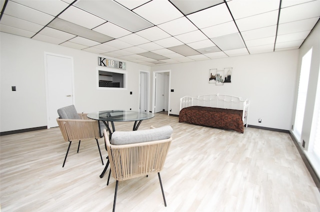 bedroom with a drop ceiling and light hardwood / wood-style flooring