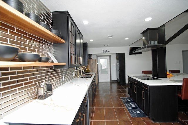 kitchen with sink, dark tile patterned floors, black electric stovetop, light stone countertops, and backsplash