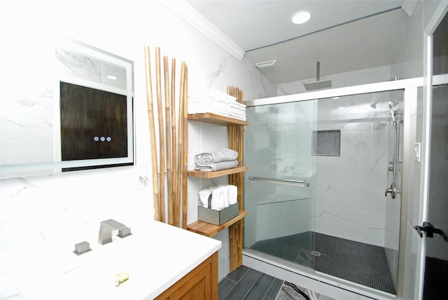 bathroom with ornamental molding, an enclosed shower, and vanity