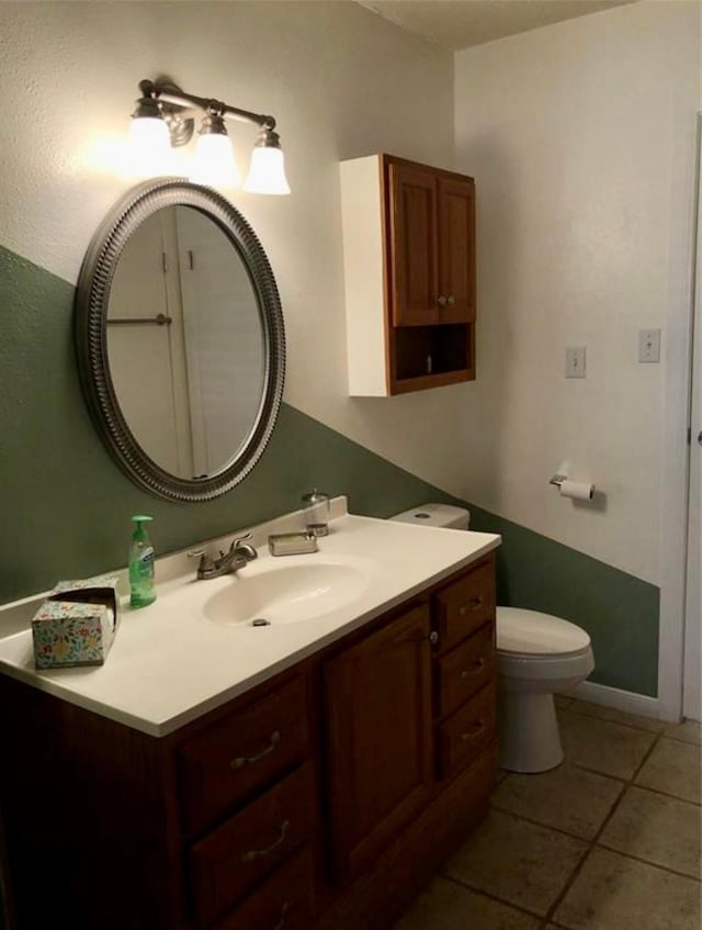 bathroom with tile patterned flooring, vanity, and toilet