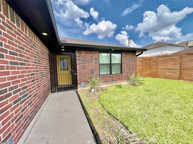 entrance to property featuring a lawn