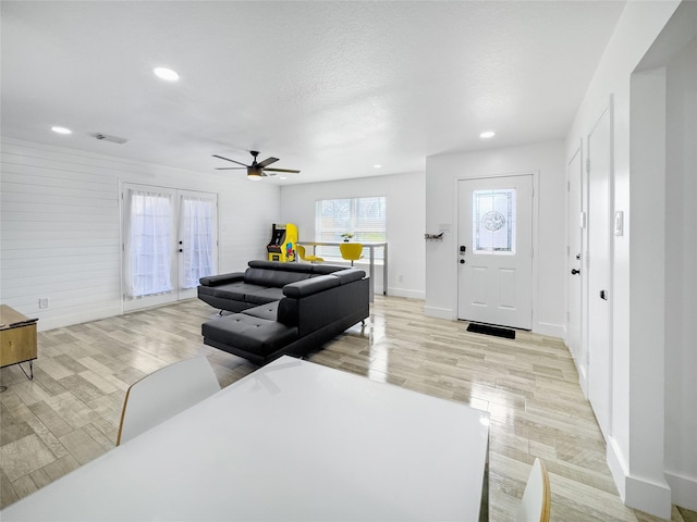 living room featuring ceiling fan, light wood-type flooring, and french doors