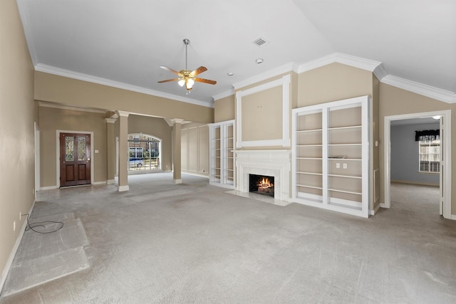 unfurnished living room featuring decorative columns, vaulted ceiling, crown molding, and a fireplace