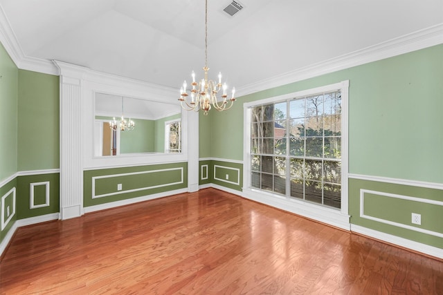 unfurnished dining area with hardwood / wood-style floors, crown molding, and a chandelier