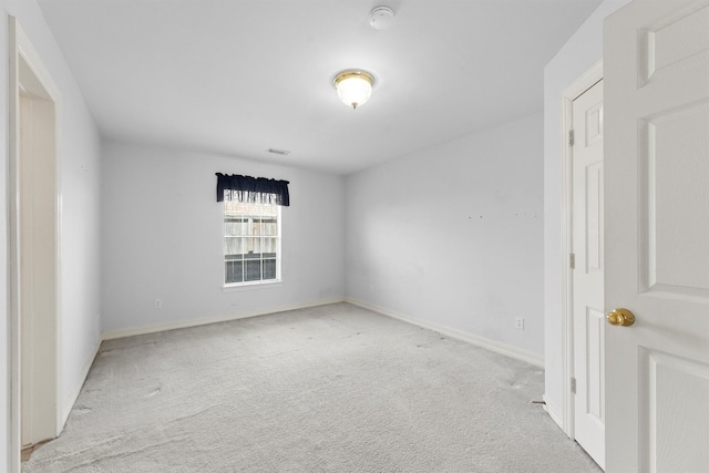 unfurnished room featuring light carpet